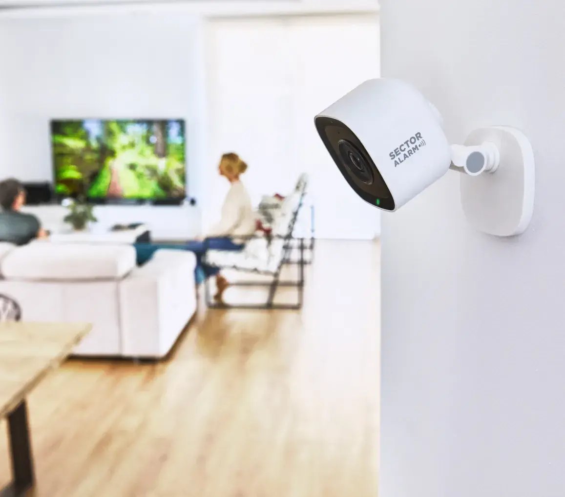 Telecamera da interno Sector Alarm installata in un salotto moderno, mentre riprende l’ambiente in alta definizione Telecamera da interno Sector Alarm installata in un salotto moderno, mentre riprende l’ambiente in alta definizione