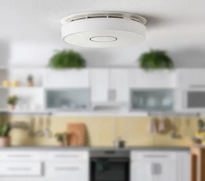 Rilevatore di fumo Sector Alarm installato a soffitto in una cucina moderna, per una protezione continua e un ambiente sempre sotto controllo.
