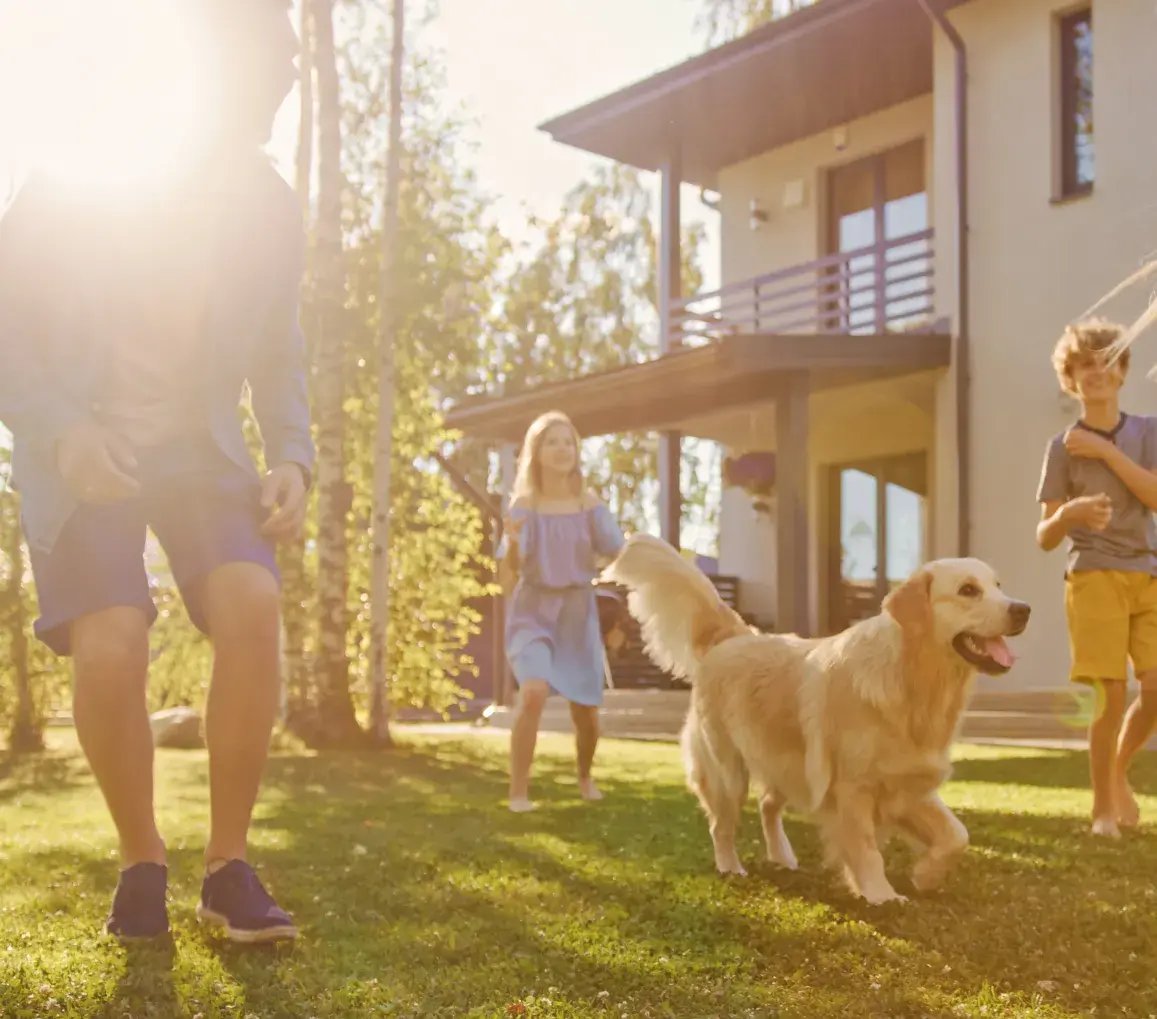 Famiglia che gioca in giardino con un cane, in un contesto sereno e protetto grazie al sistema Sector Alarm Famiglia che gioca in giardino con un cane, in un contesto sereno e protetto grazie al sistema Sector Alarm